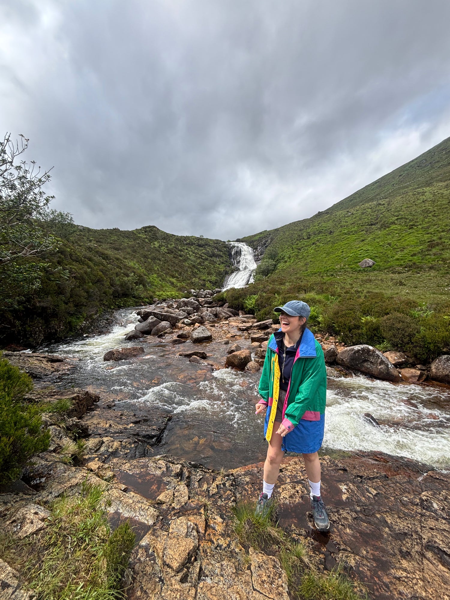 Founder Beth Wright in front of waterfall in Scotland laughing